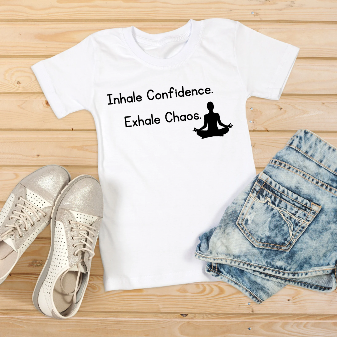 A white graphic t-shirt with the text 'Inhale Confidence. Exhale Chaos.
