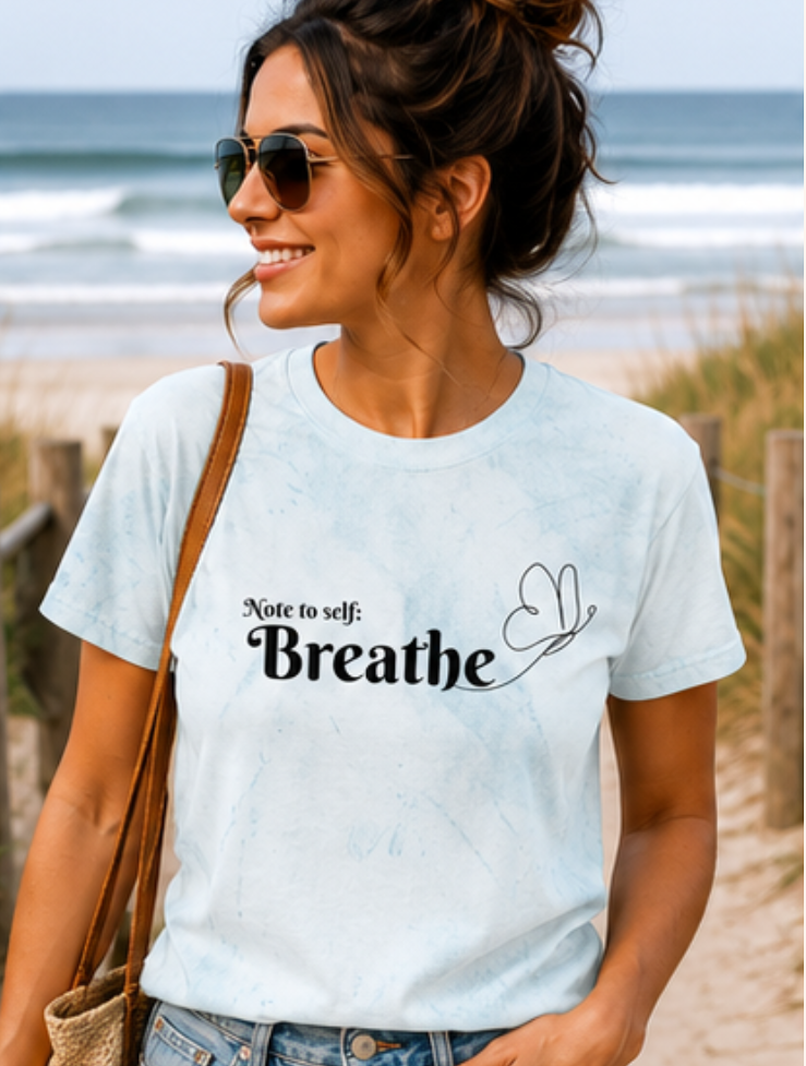 Woman wearing a t-shirt with 'Breathe' text on a beach